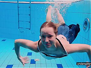 redhead honey swimming bare in the pool